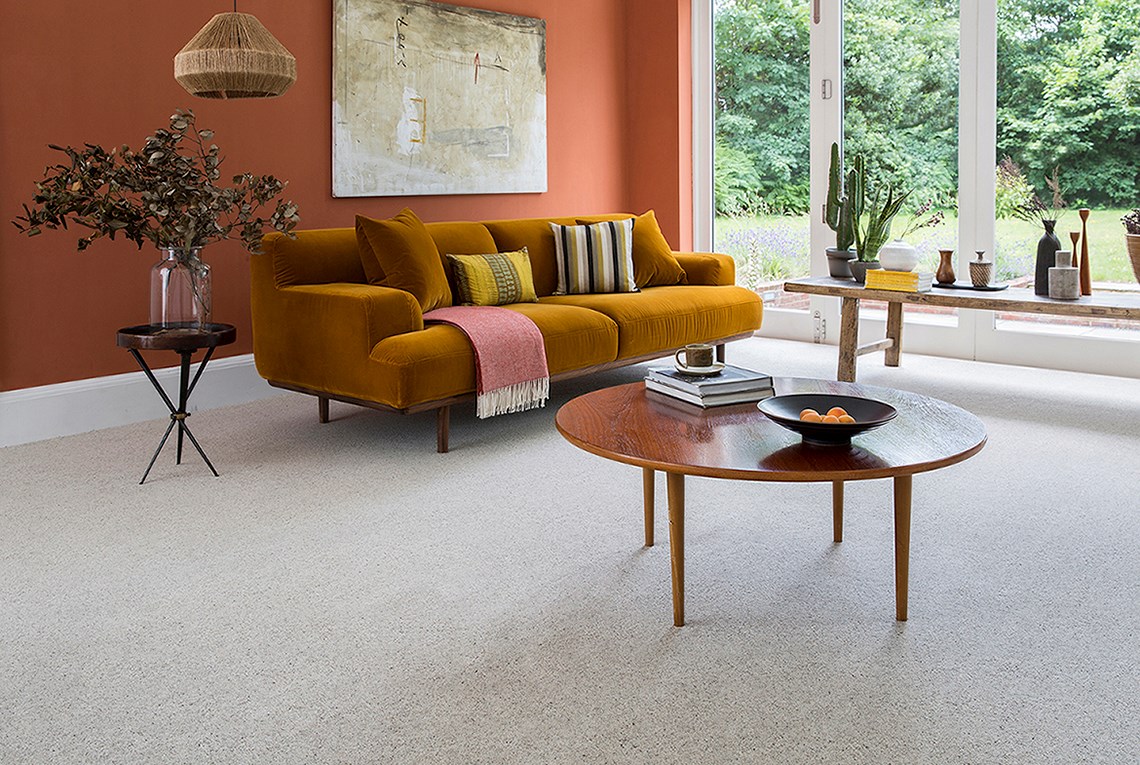 Yellow couch and wooden table on Cormar's Primo Naturals Wild Honey Carpet